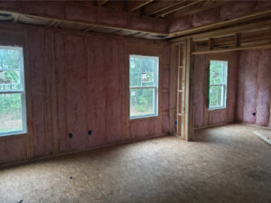 Fiberglass wall insulation in a new home with several windows.