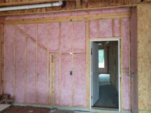 Fiberglass wall insulation in a new home with a doorway.